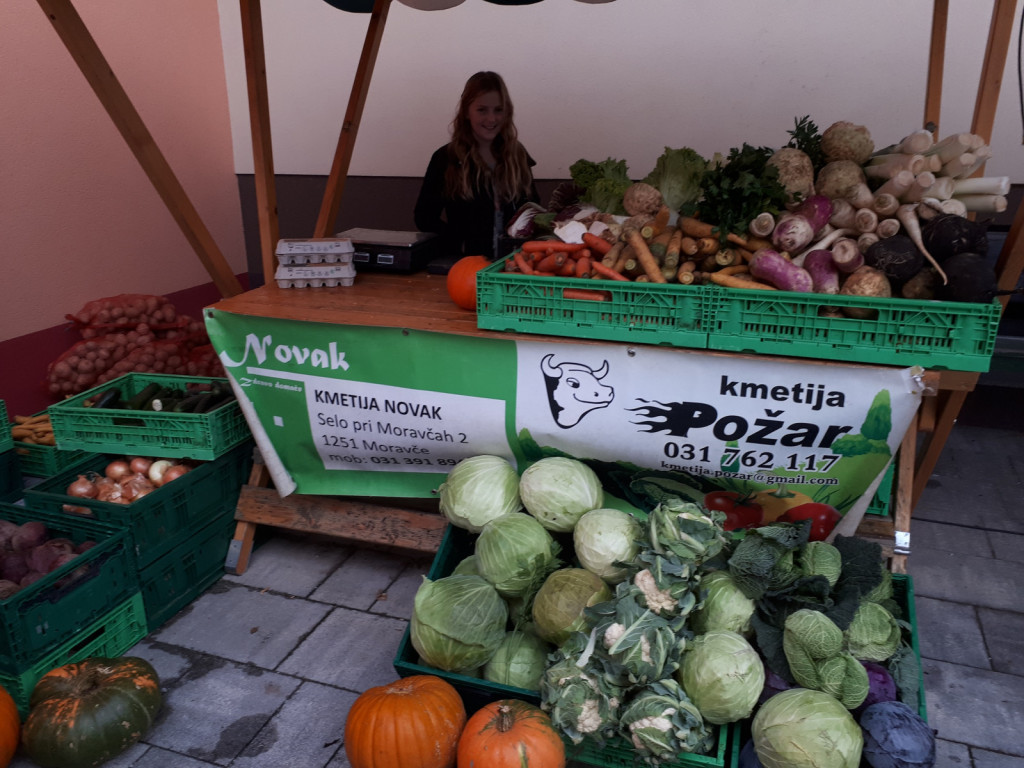 Ajda rada pomaga pri prodaji zelenjave na tržnici v Moravčah. 